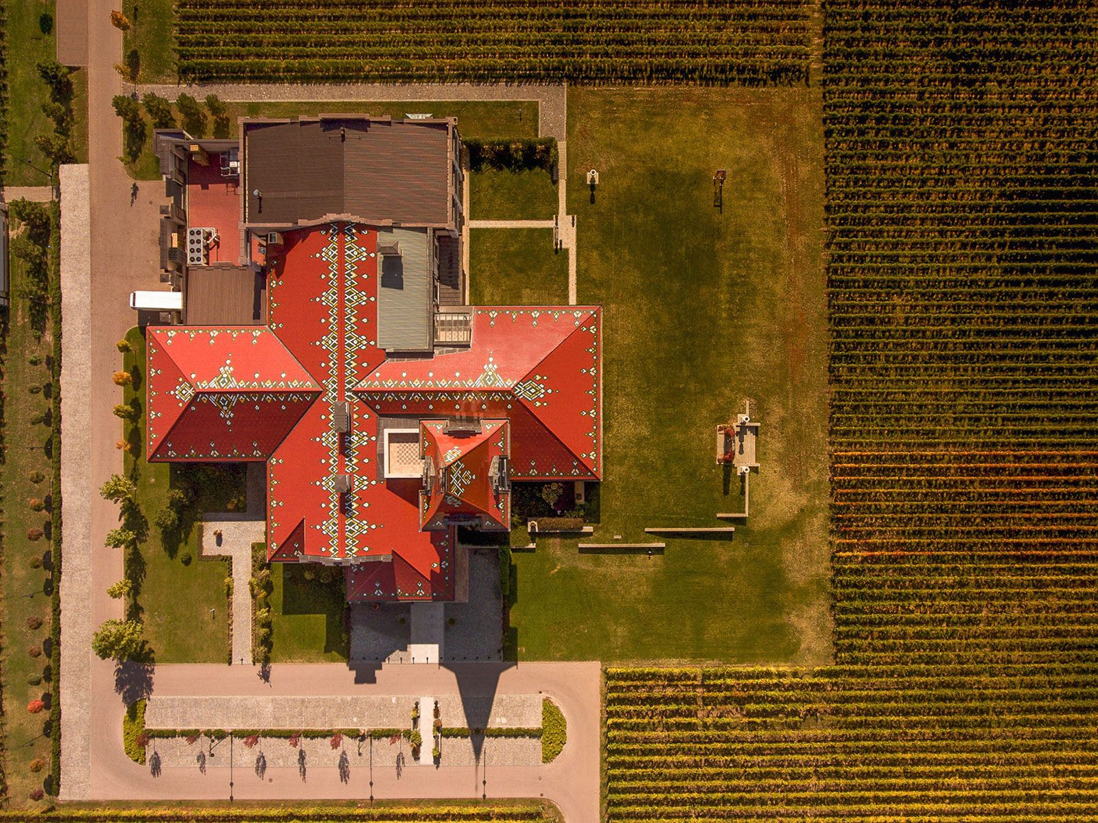 Snimak iz vazduha vinarije Zvonko Bogdan sa šarenim krovom i redovima vinove loze