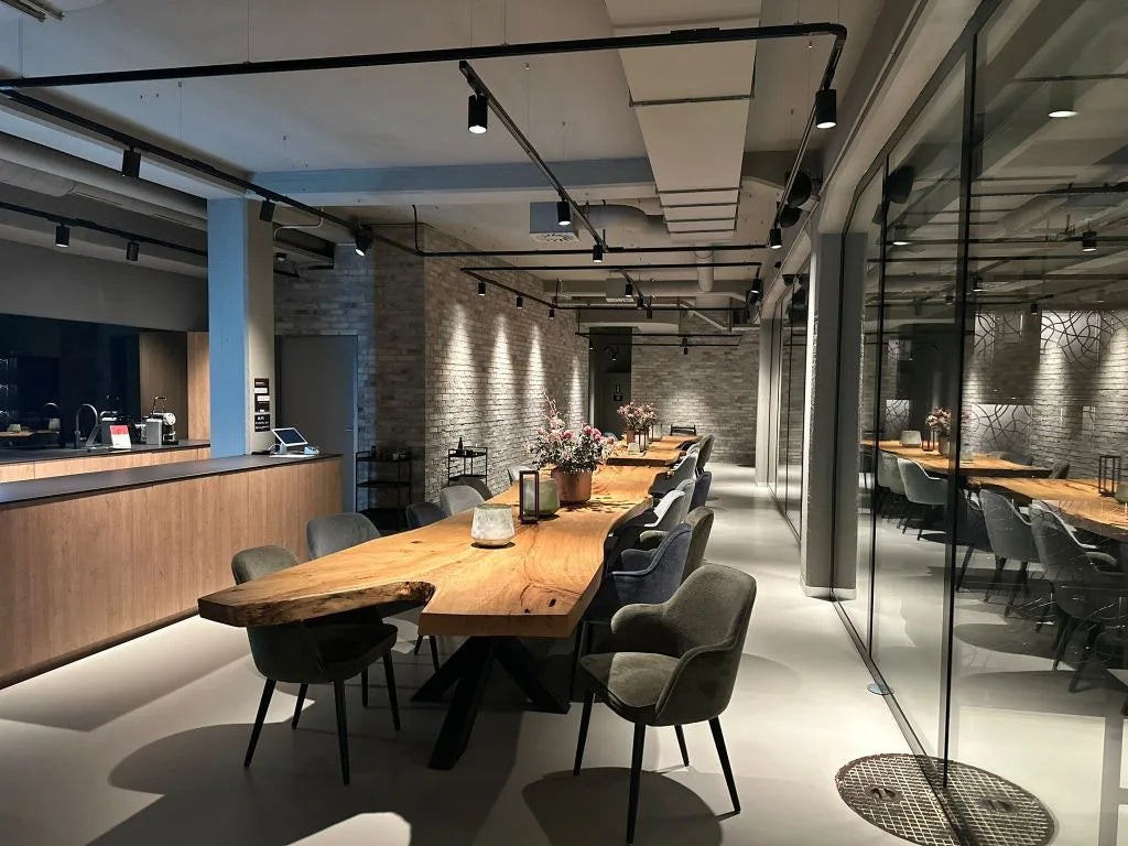 Langer Naturholztisch mit grauen Polsterstühlen, Bar aus Eichenholz und Backsteinwand im Private Member Club von my winetime